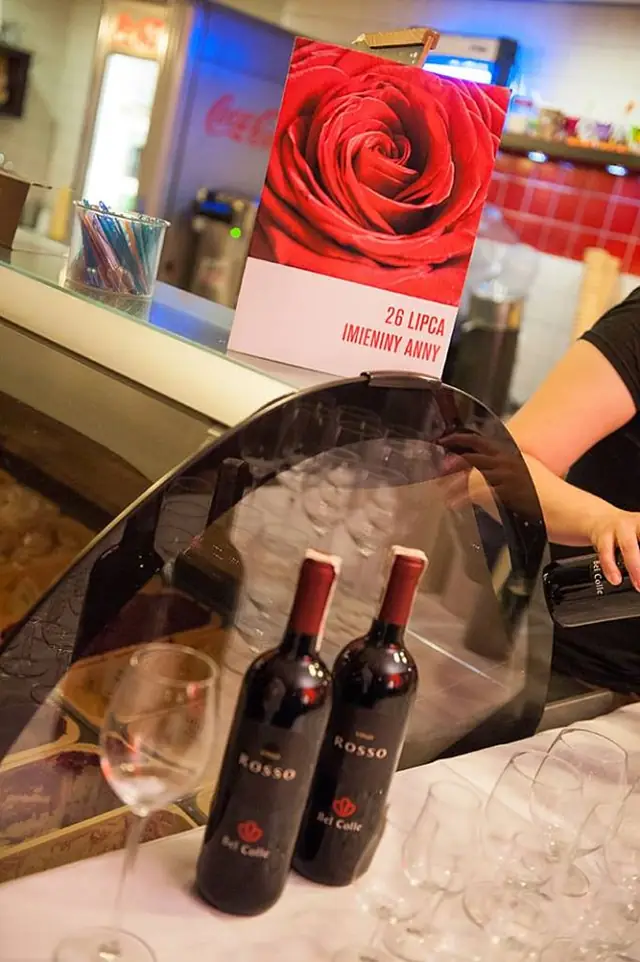 Butelki wina i róża na stoliku w klubie