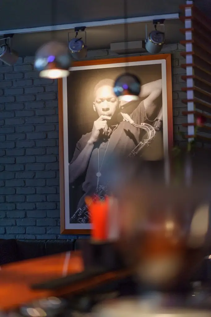 Portret muzyka jazzowego na ścianie klubu, w tle bar